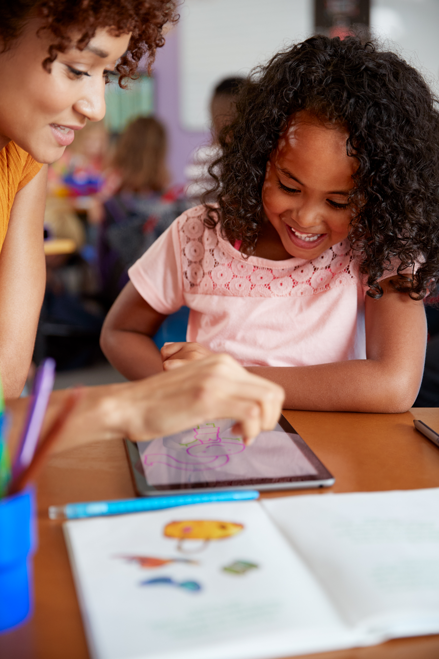 Teacher helping child with drawing